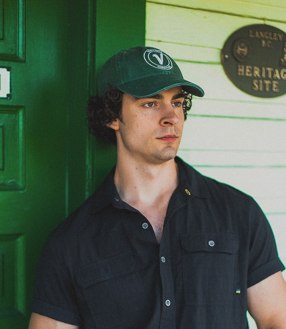 Close-up of a male model wearing the pine and white Elation relaxed-fit hat by Vancouver Signature