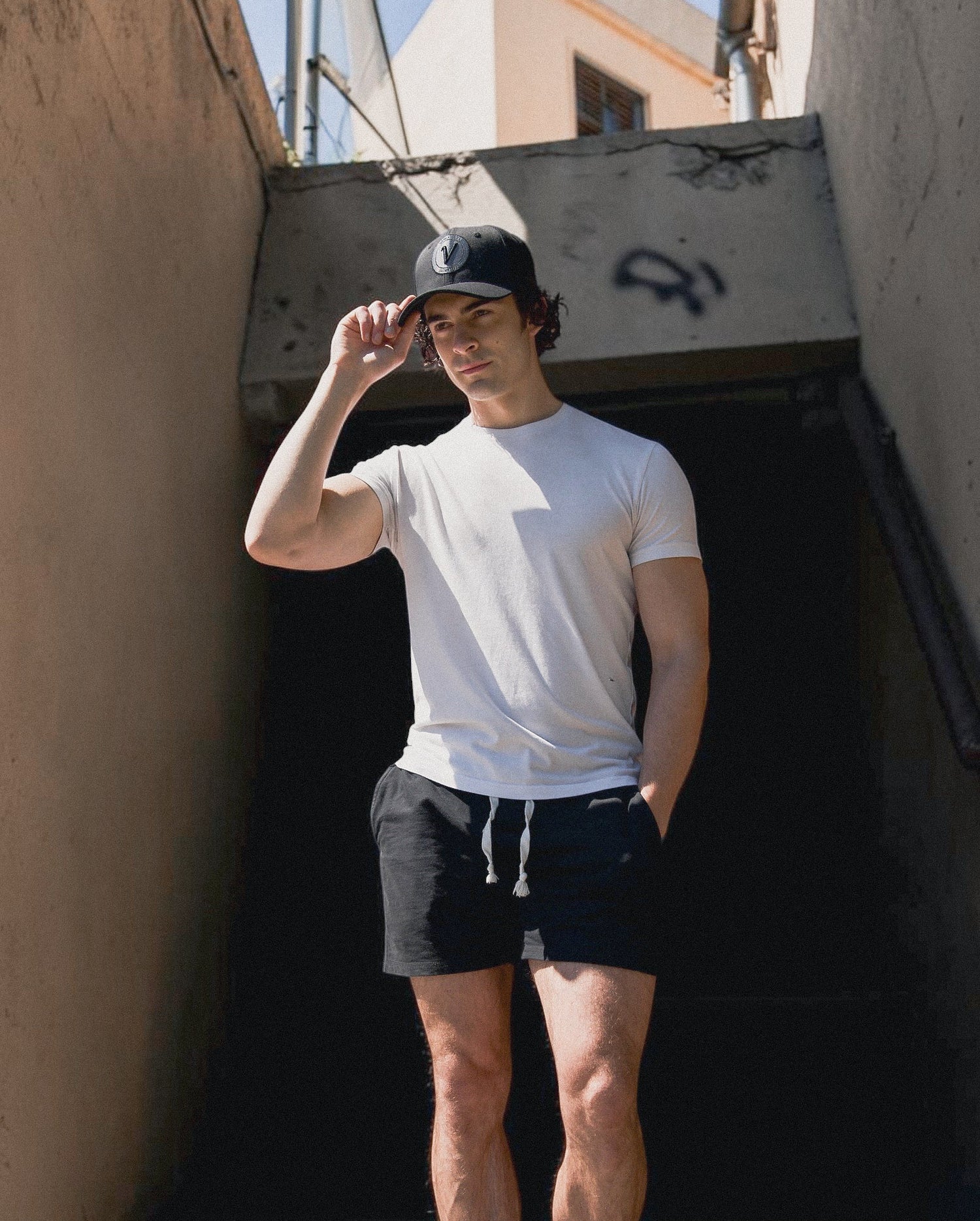 Male model holding the brim of the First Up hat by Vancouver Signature