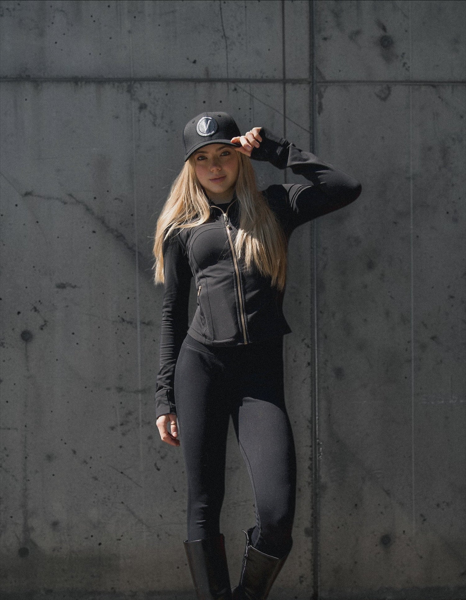 Female model wearing the black and white First-Up lifestyle hat outdoors in an urban setting