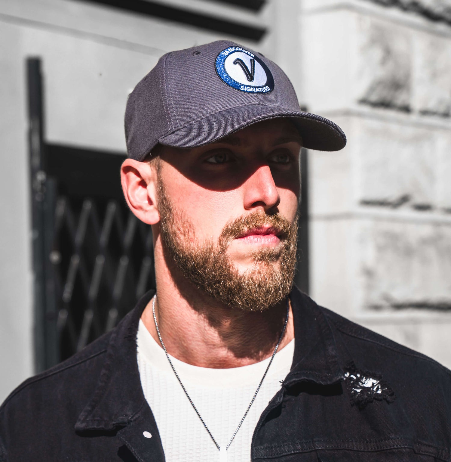 Man wearing Vancouver Signature Listo structured hat in stone and black