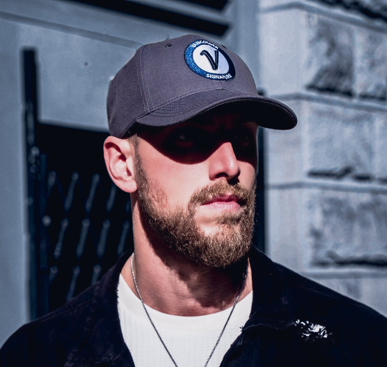 Man wearing Vancouver Signature Listo structured hat in stone and black