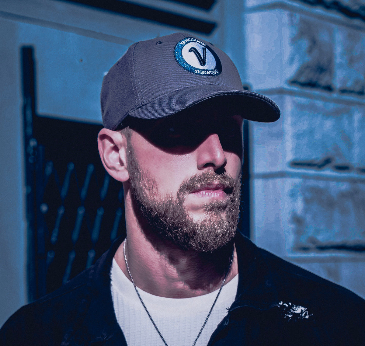 Man wearing Vancouver Signature Listo structured hat in stone and black