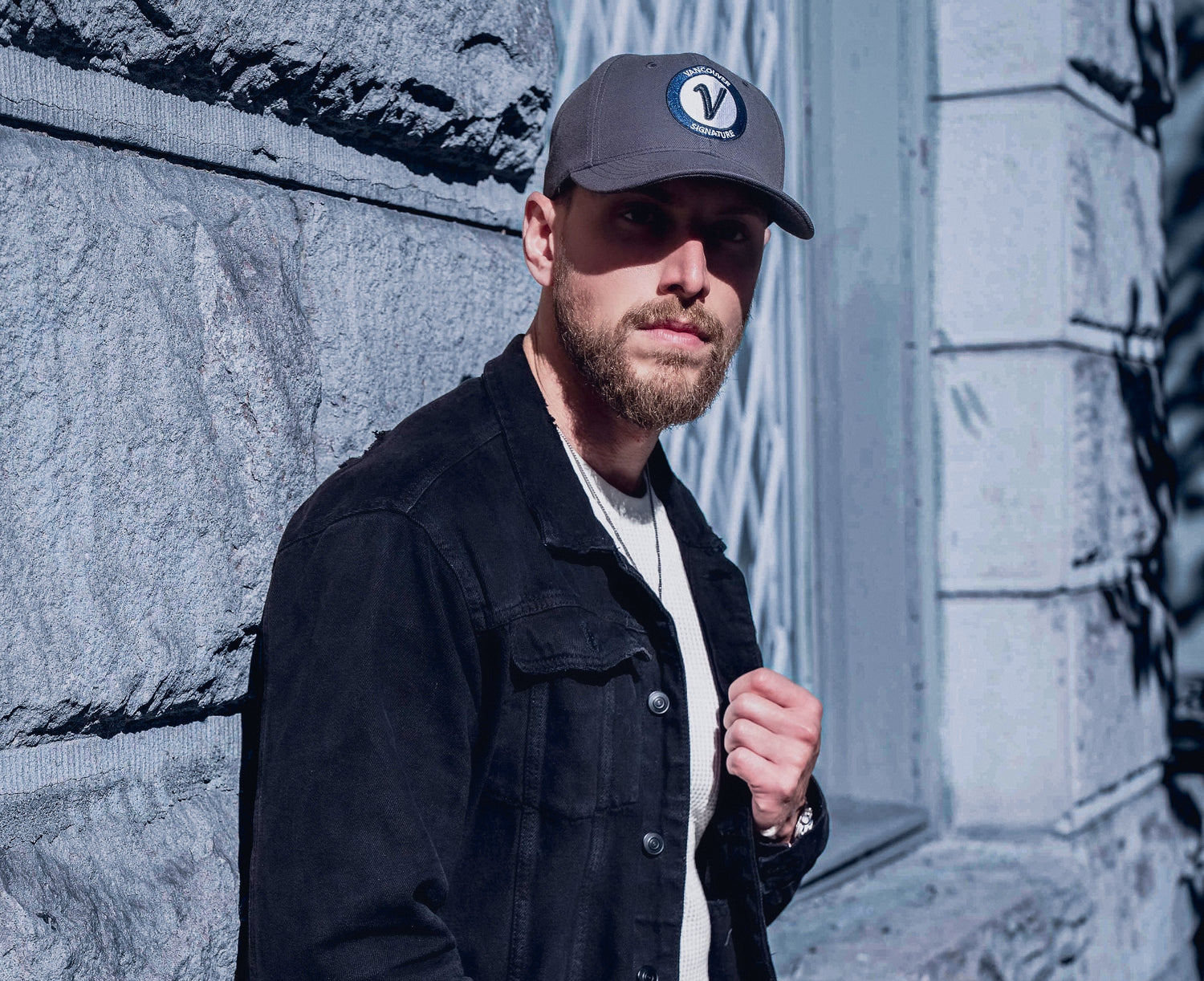 Man wearing Vancouver Signature Listo premium hat in stone and black outside
