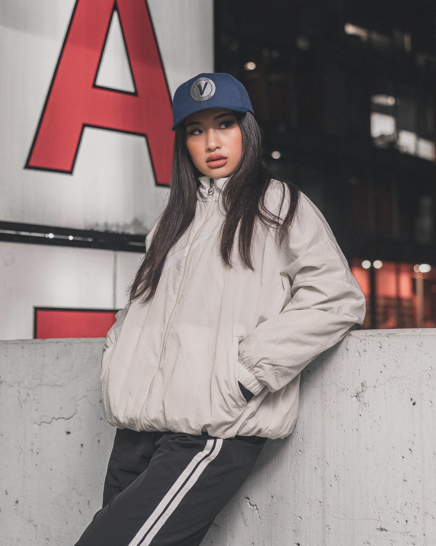 Female model leaning against a wall wearing the First-Up hat from Vancouver Signature
