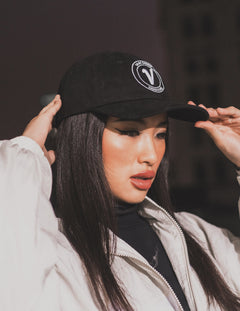 Close-up of a female model with both hands on the black and white Elation relaxed-fit hat by Vancouver Signature