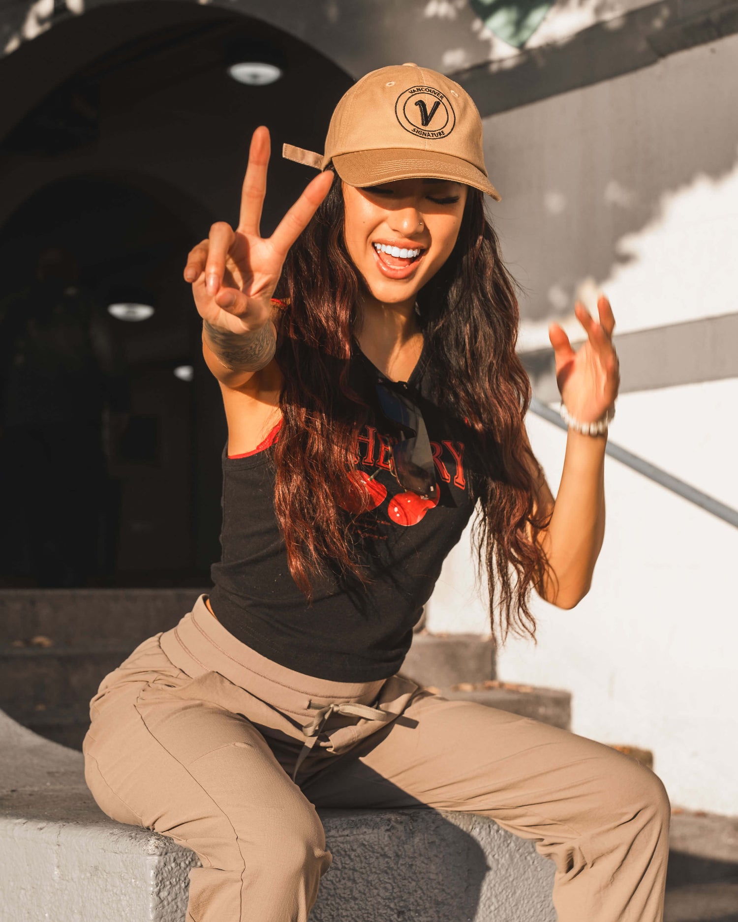 Woman wearing Vancouver Signature Elation relaxed hat in sand and black