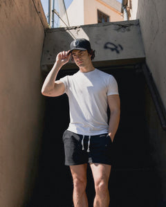 Male model holding the brim of the First Up hat by Vancouver Signature