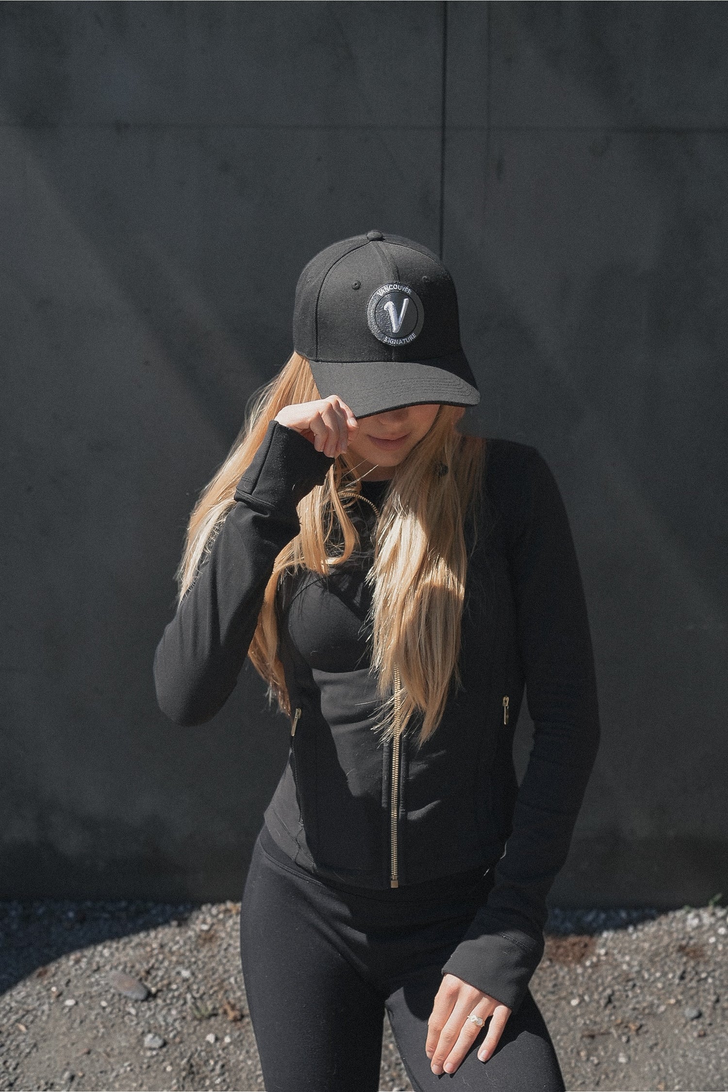 Female model wearing the black and white First-Up lifestyle hat outdoors