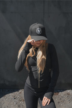 Female model wearing the black and white First-Up lifestyle hat outdoors