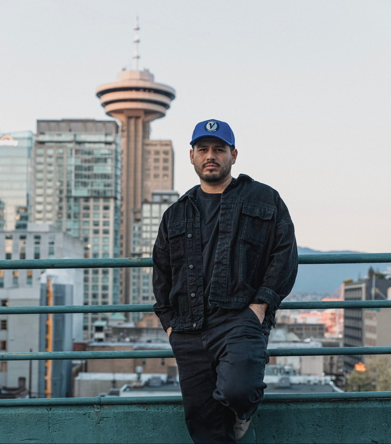Male model wearing the royal and black First-Up lifestyle hat outdoors in Vancouver