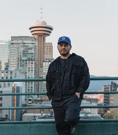 Male model wearing the royal and black First-Up lifestyle hat outdoors in Vancouver