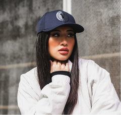 Close-up profile of a woman wearing the True-Navy and black First-Up athleisure hat