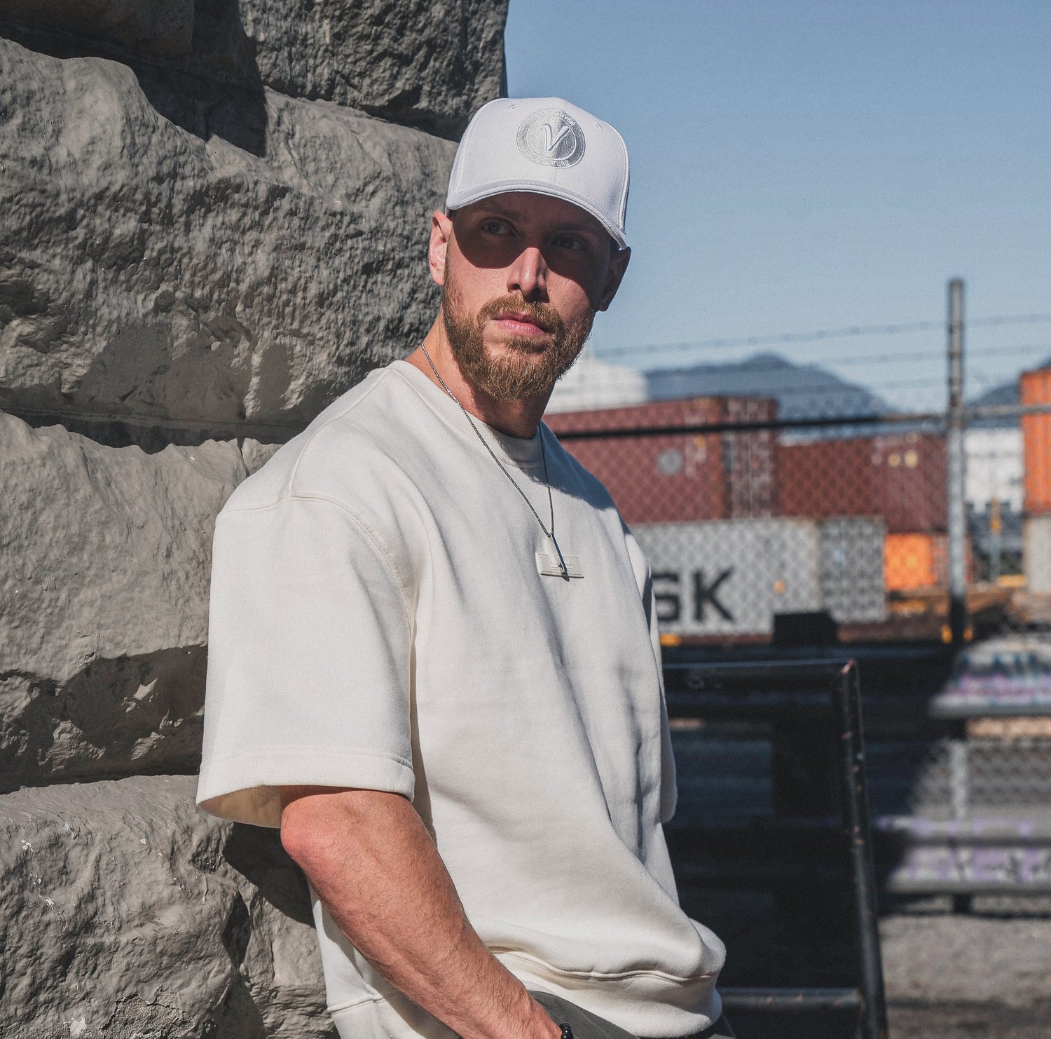 Male model wearing the white and white First-Up lifestyle hat outdoors