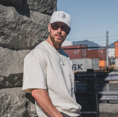 Male model wearing the white and white First-Up lifestyle hat outdoors
